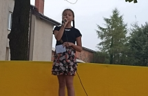 Dziewczynka z warkoczami spiewa do mikrofonu